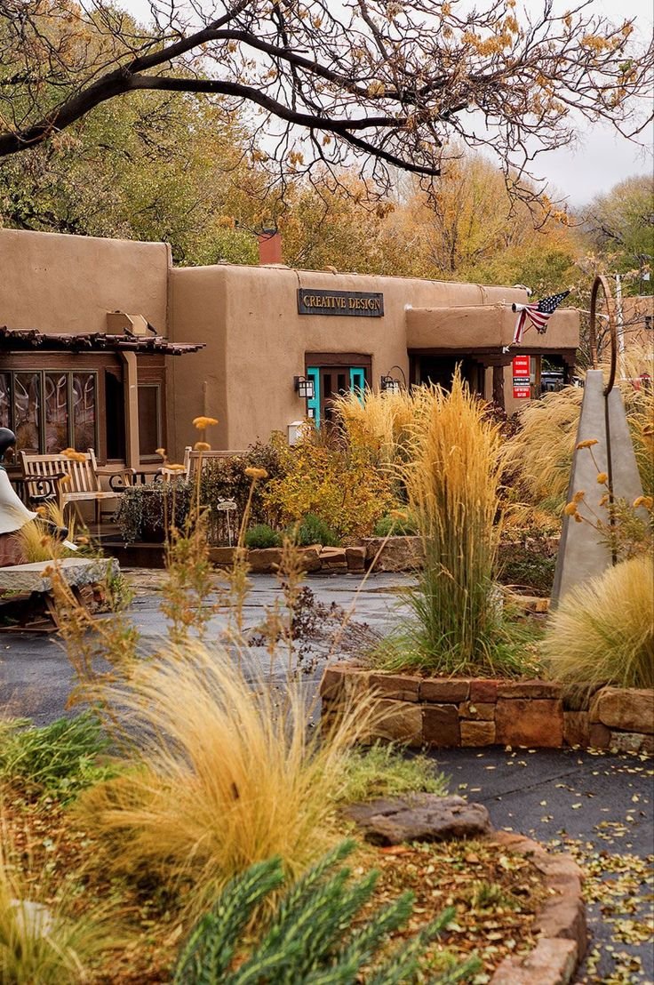 This may contain: an adobe style building surrounded by plants and trees