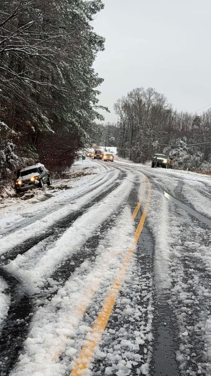 This may contain: cars driving down a snow covered road in the winter