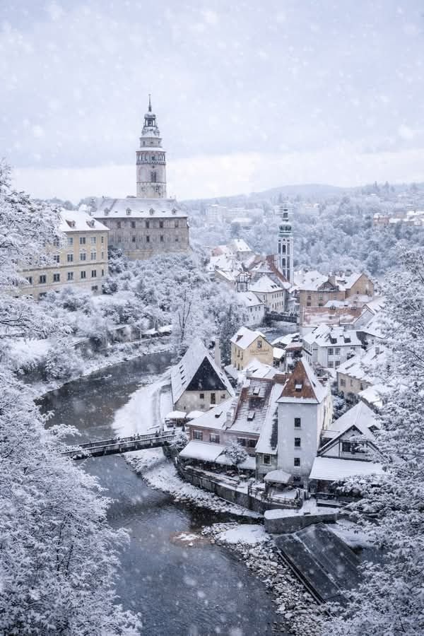 This may contain: an aerial view of a town in the winter with snow falling on it's roofs