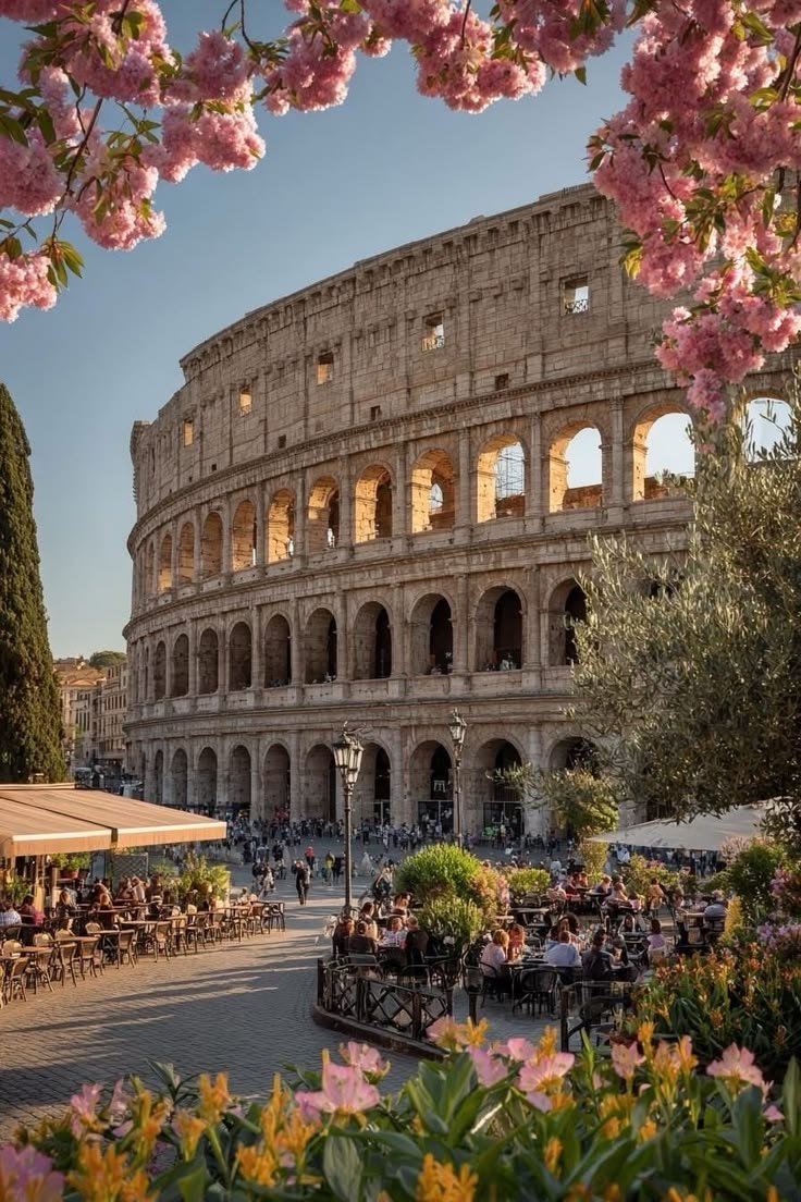This may contain: the colossion in rome, italy is surrounded by pink flowers and greenery