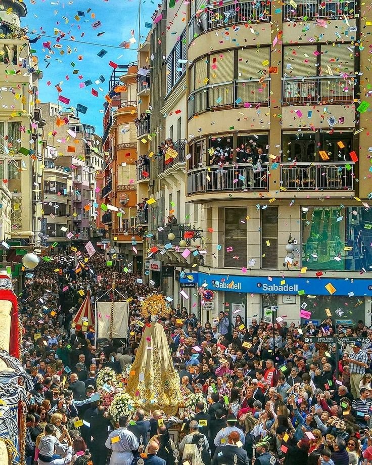 This may contain: a large group of people walking down a street with confetti in the air