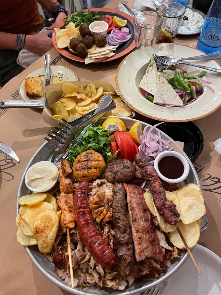 This may contain: a table topped with plates and bowls filled with different types of food on top of it