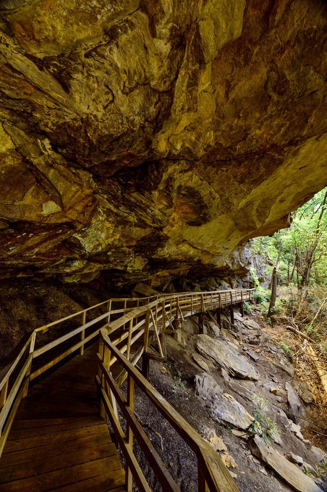 This may contain: a wooden walkway leading to a cave entrance