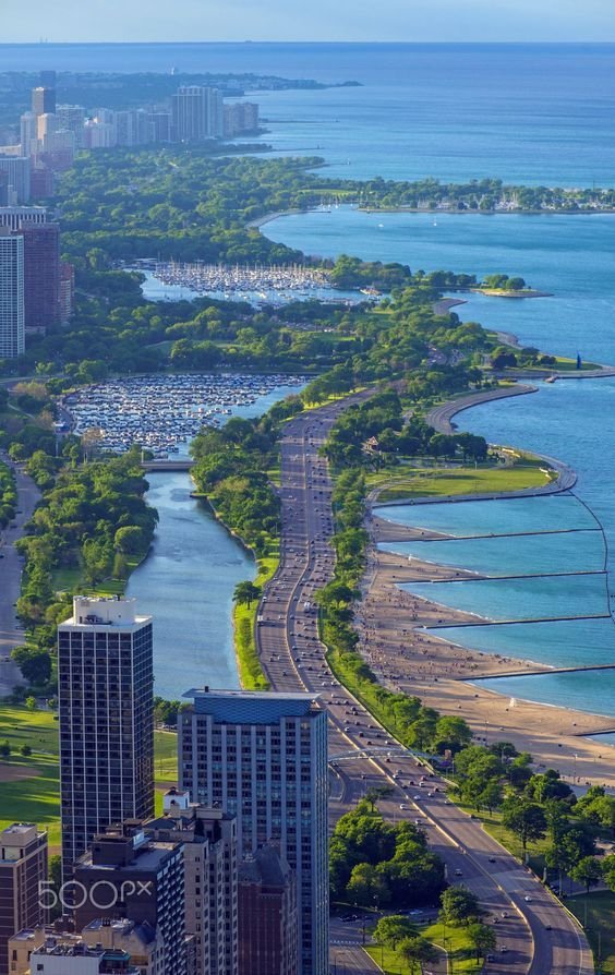 This may contain: an aerial view of a city and the ocean with tall buildings in the foreground