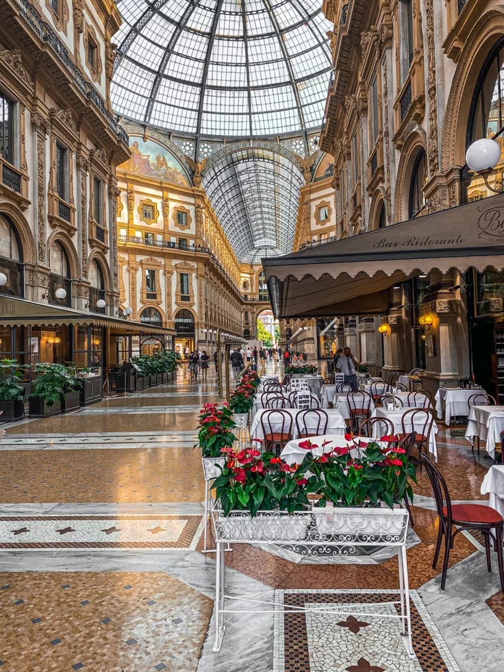 This may contain: the interior of a shopping mall with tables and chairs set up in front of them