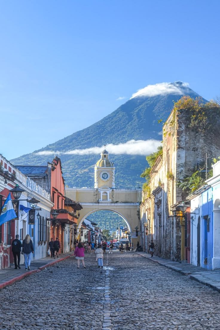 This may contain: people are walking down an old cobblestone street