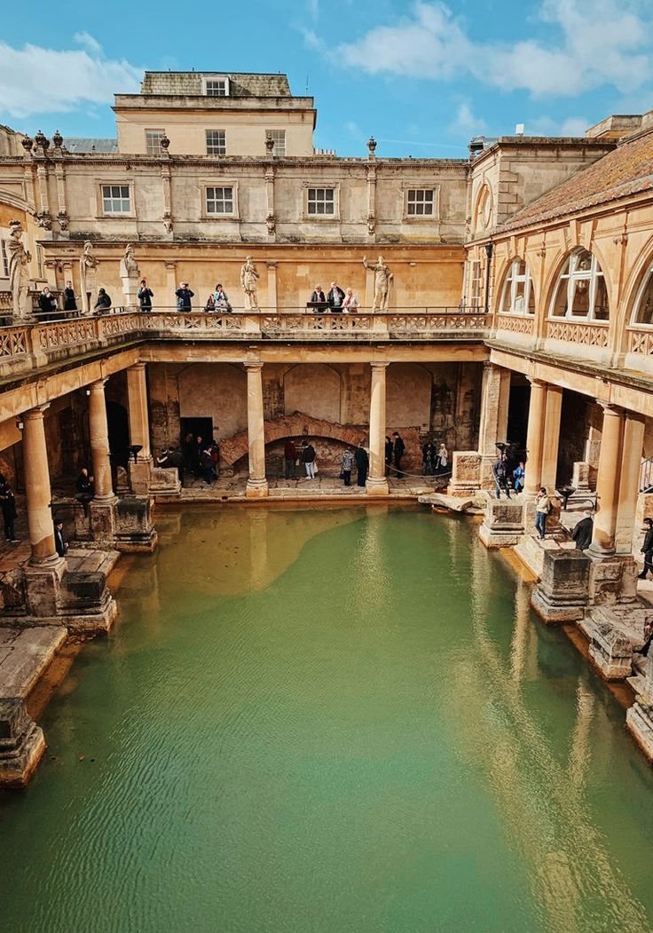 This may contain: a large pool in the middle of an old building