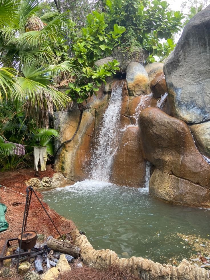 This may contain: there is a small waterfall in the middle of this garden