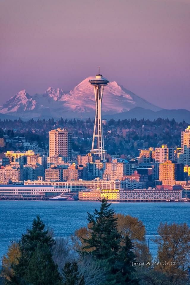 This may contain: the space needle in seattle, with mt rainier in the background