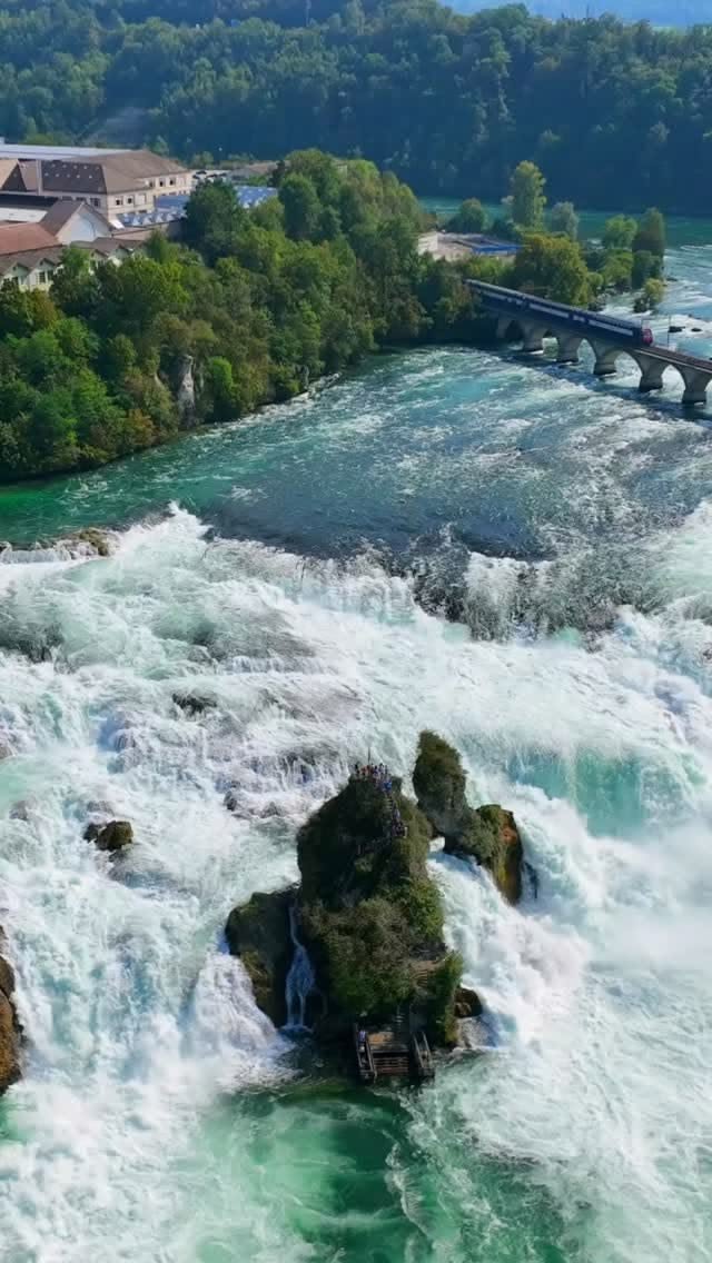 This may contain: an aerial view of a river with rapids and bridge in the background on a sunny day
