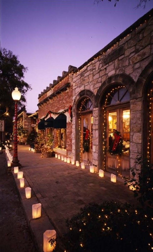 This may contain: lighted candles are lined up on the side of a building