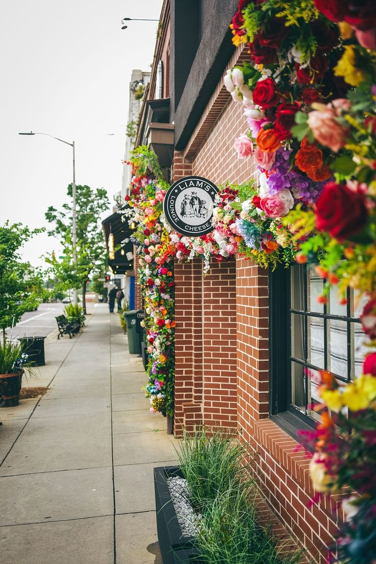This may contain: a brick building with flowers hanging from it's side