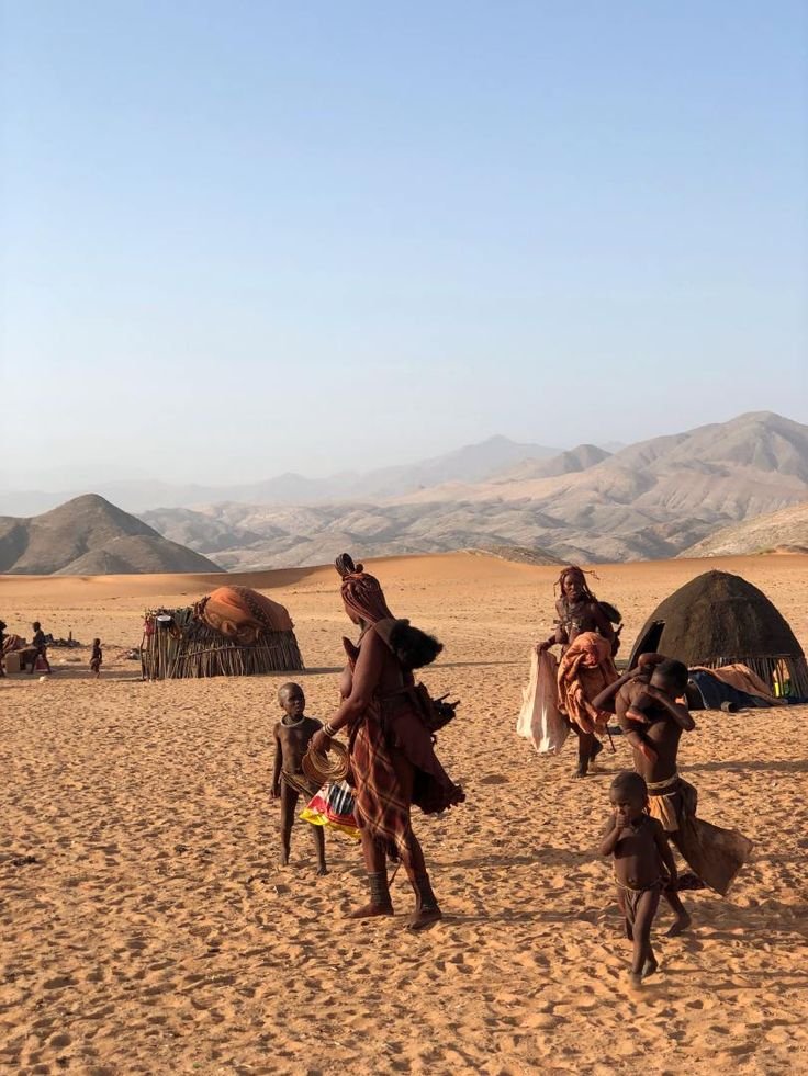 This may contain: some people are riding horses in the desert