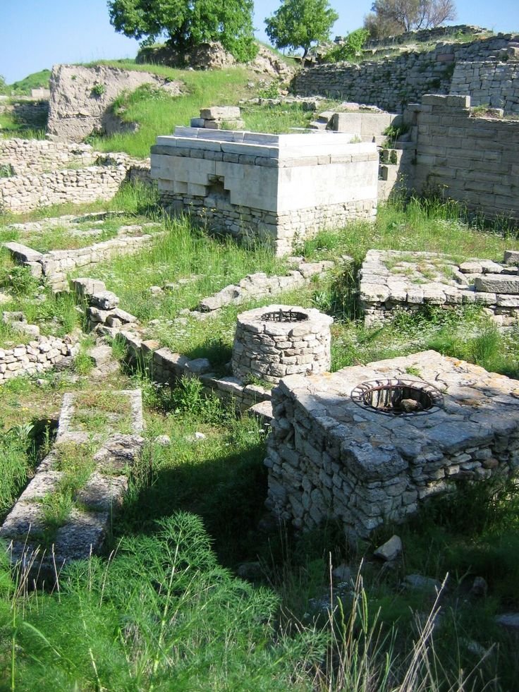 This may contain: an old stone building sitting in the middle of a field