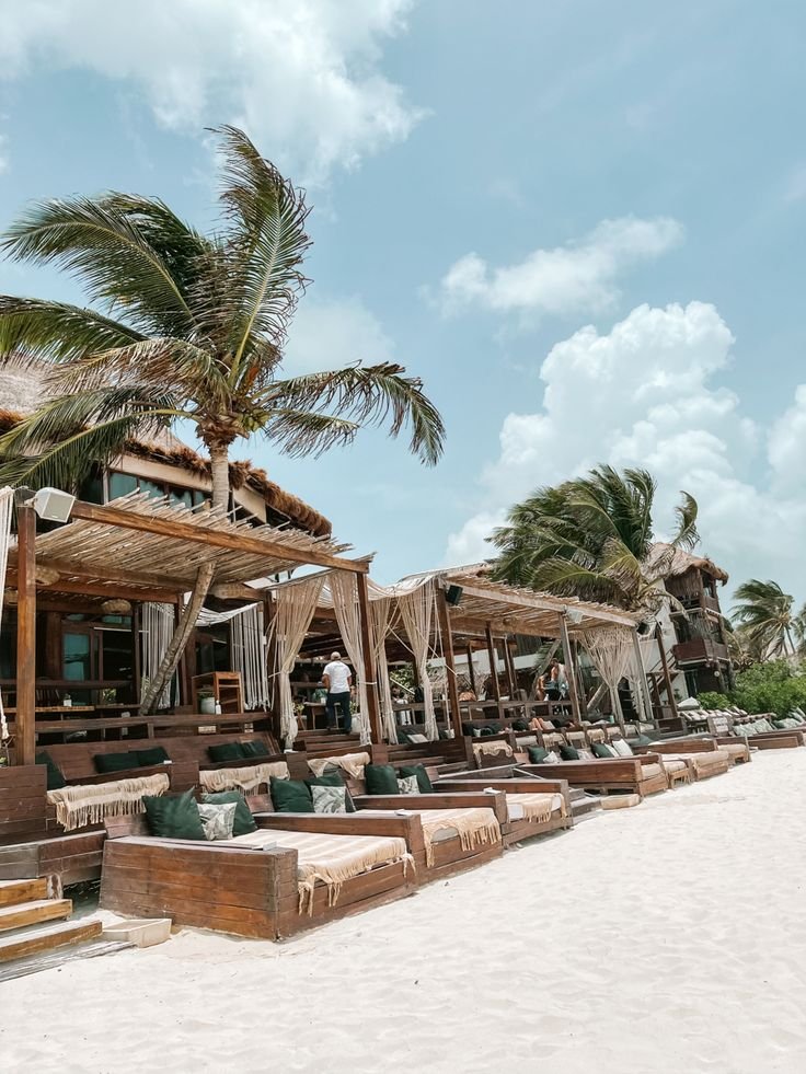 This may contain: the beach is lined with lounge chairs and palm trees