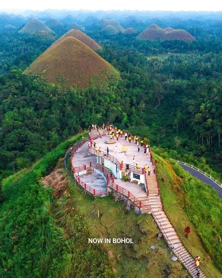 This may contain: an aerial view of some hills and trees with stairs leading up to the top in front of them