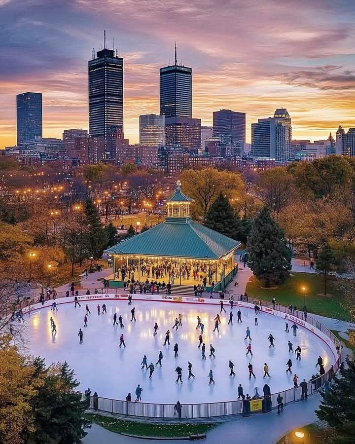 This may contain: people skating on an ice rink in front of the city skyline at dusk with lights