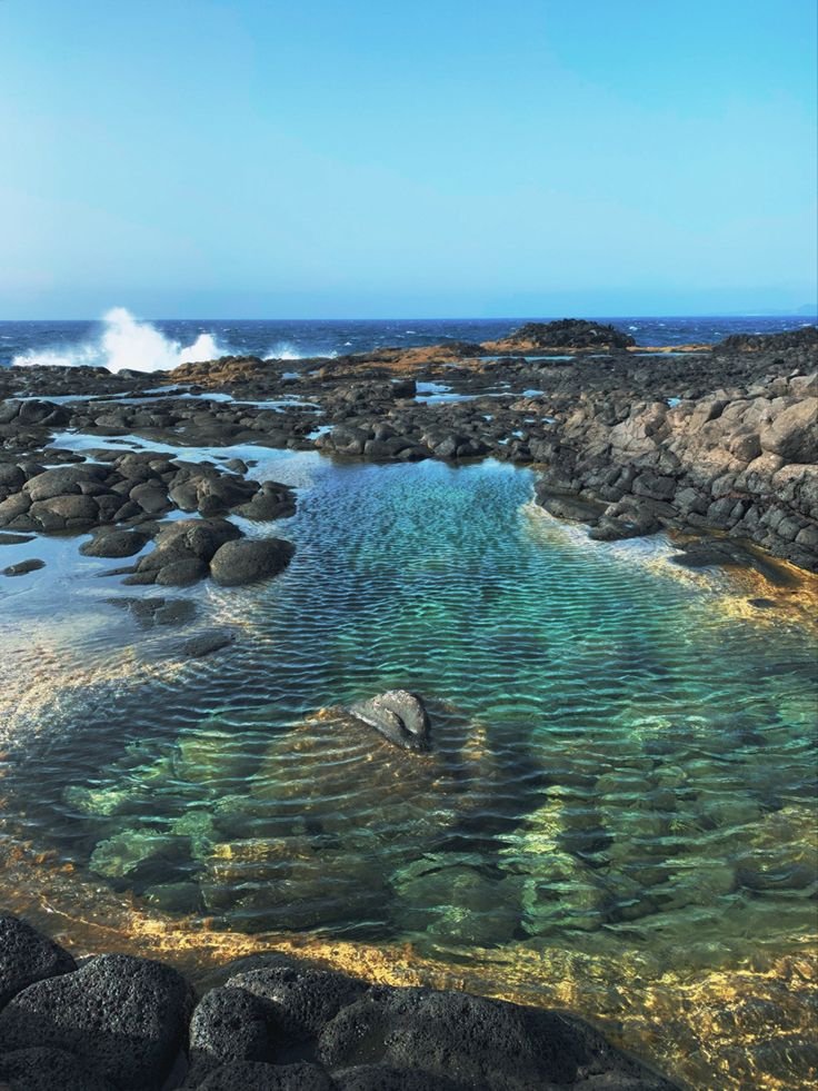 This may contain: the water is crystal clear and blue in this photo, it looks like there are waves coming out of the rocks