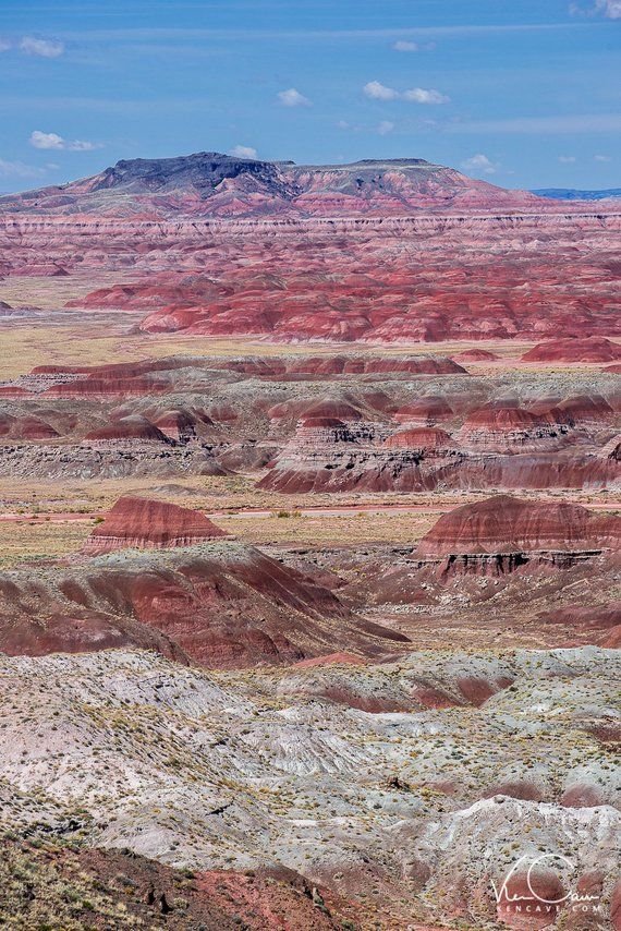 This may contain: the landscape is very colorful and there are many hills in the distance with trees on each side