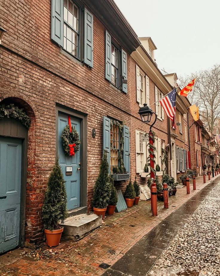 This may contain: a row of brick buildings with wreaths on the windows