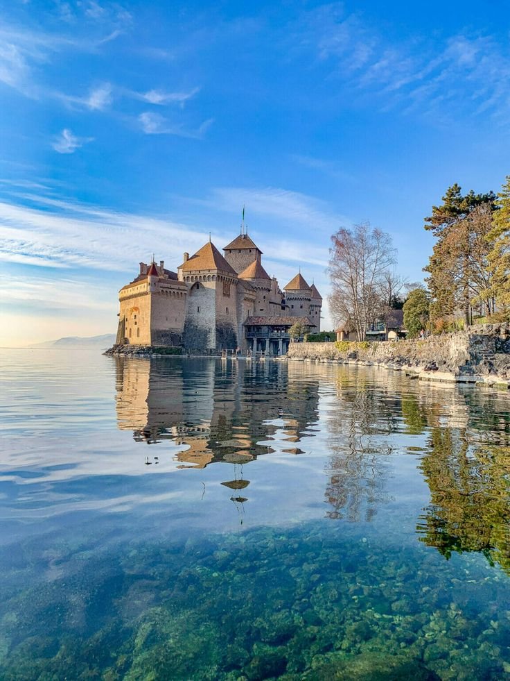 This may contain: an old castle sitting on top of a body of water