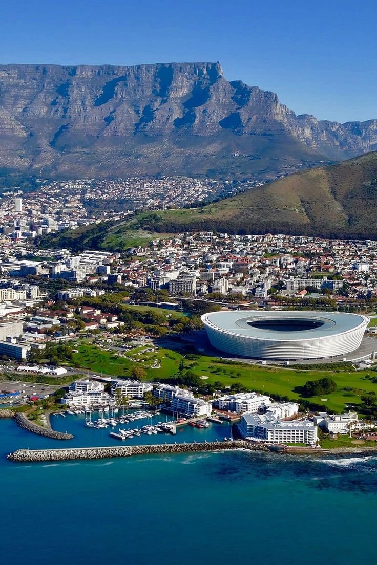 This may contain: an aerial view of cape town with table mountain in the background, and water surrounding it