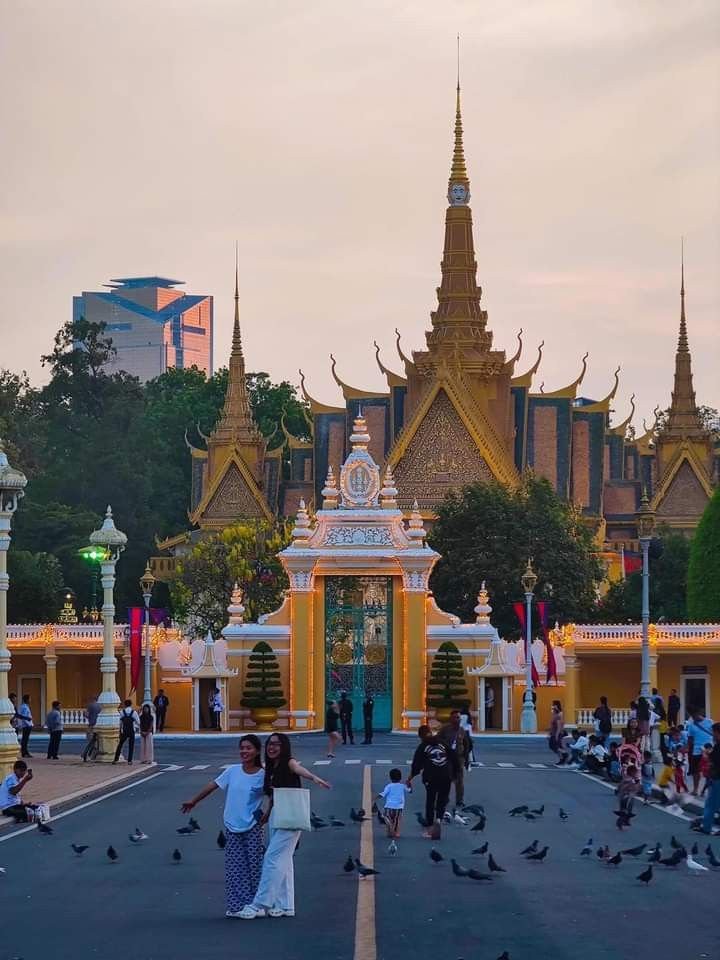 This may contain: many people are walking around in front of a large building with gold and white decorations