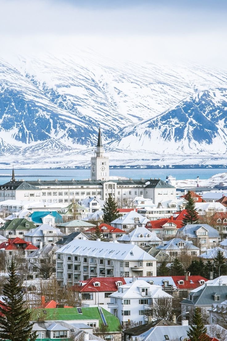 This may contain: a city with snow covered mountains in the background