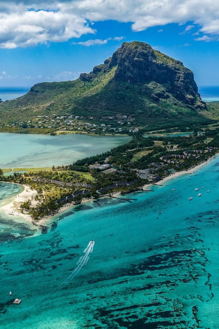 This may contain: an island in the middle of some water with boats floating on it's sides