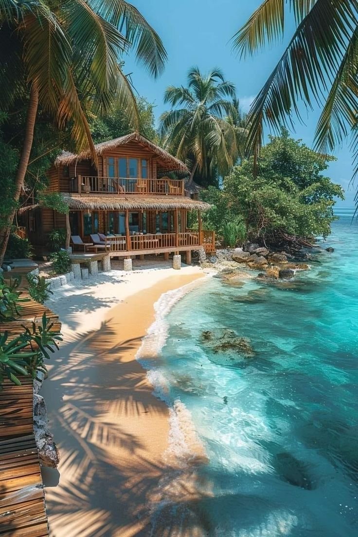 This may contain: a house on the beach surrounded by palm trees and clear blue water with white sand